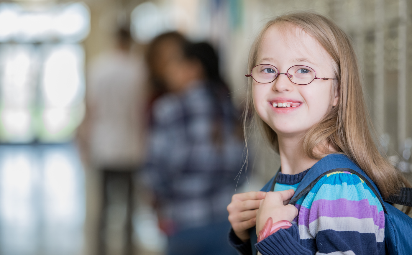 Junior high school student with Down Syndrome smiles on her way to class.