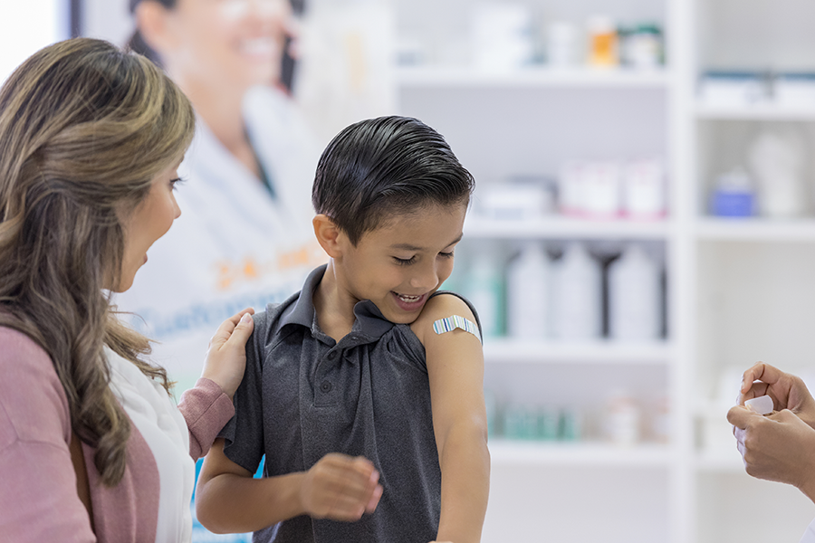 Boy with bandage on arm after receiving vaccination.