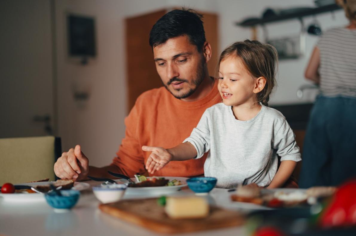 Young girl having healthy breakfast with her dad