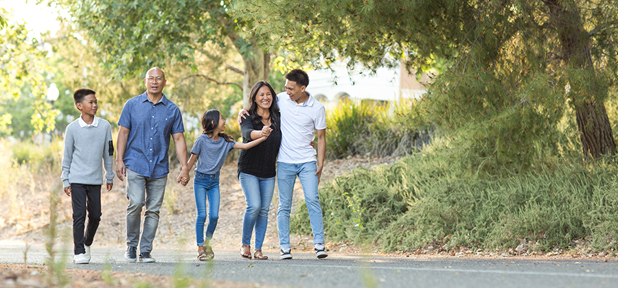 Family walking on trail through woods.